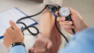 Ein Arzt misst den Blutdruck am Arm eines Patienten