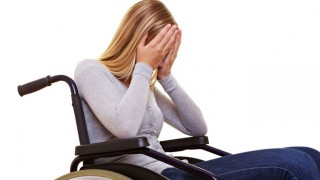 Eine junge, blonde Frau sitzt im Rollstuhl
