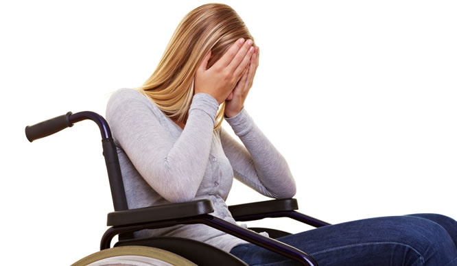 Eine junge, blonde Frau sitzt im Rollstuhl