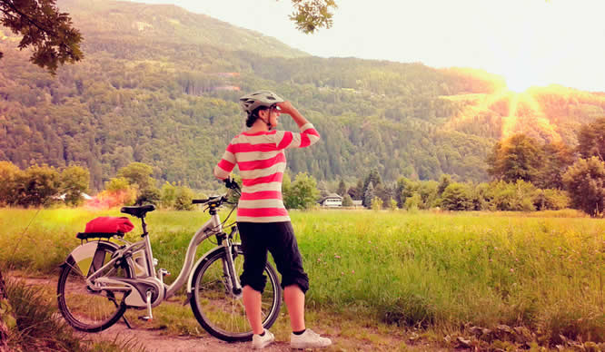 Eine Frau legt bei ihrer Radtour eine Pause ein