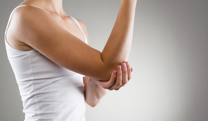 Eine Frau hat Muskelschmerzen am Arm
