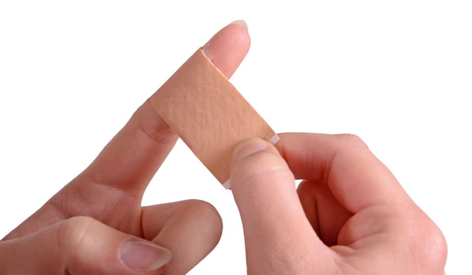 Ein Finger wird mit einem Pflaster verbunden