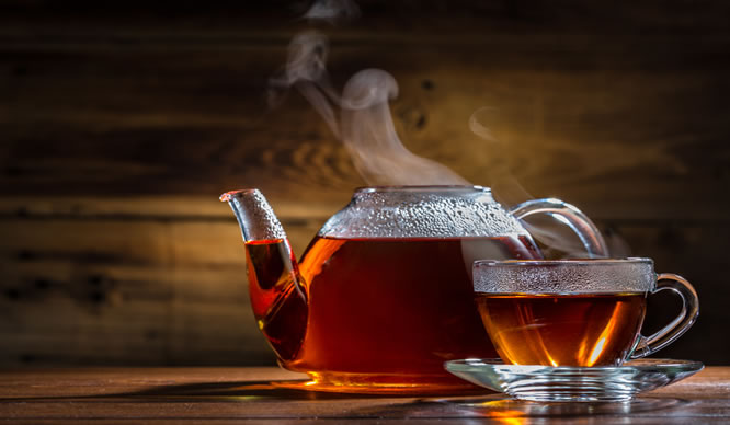 Eine dampfende Teekanne mit einer Tasse