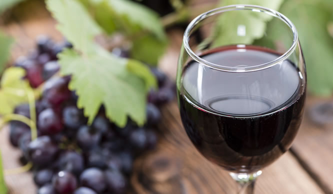 Ein Glas Rotwein mit Trauben