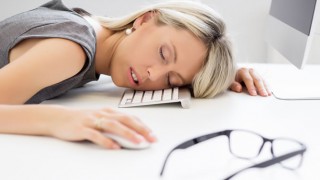 Eine Frau schläft am Arbeitsplatz