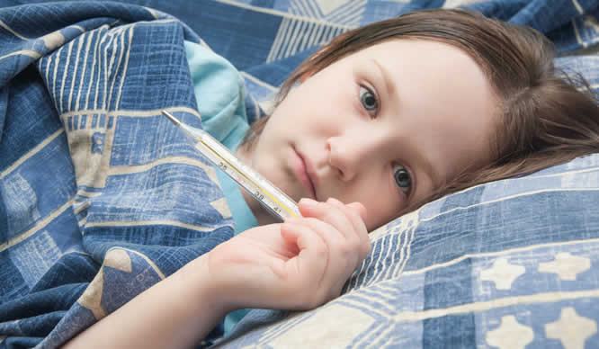 Eine kleines Mädchen liegt mit Fieber im Bett