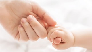 Eine Mutter hält die Hand ihres Babys